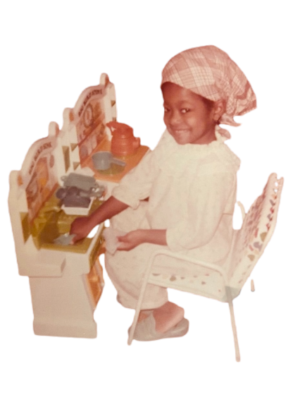 young afro peurto rican girl with scarf playing on towy kitchen set